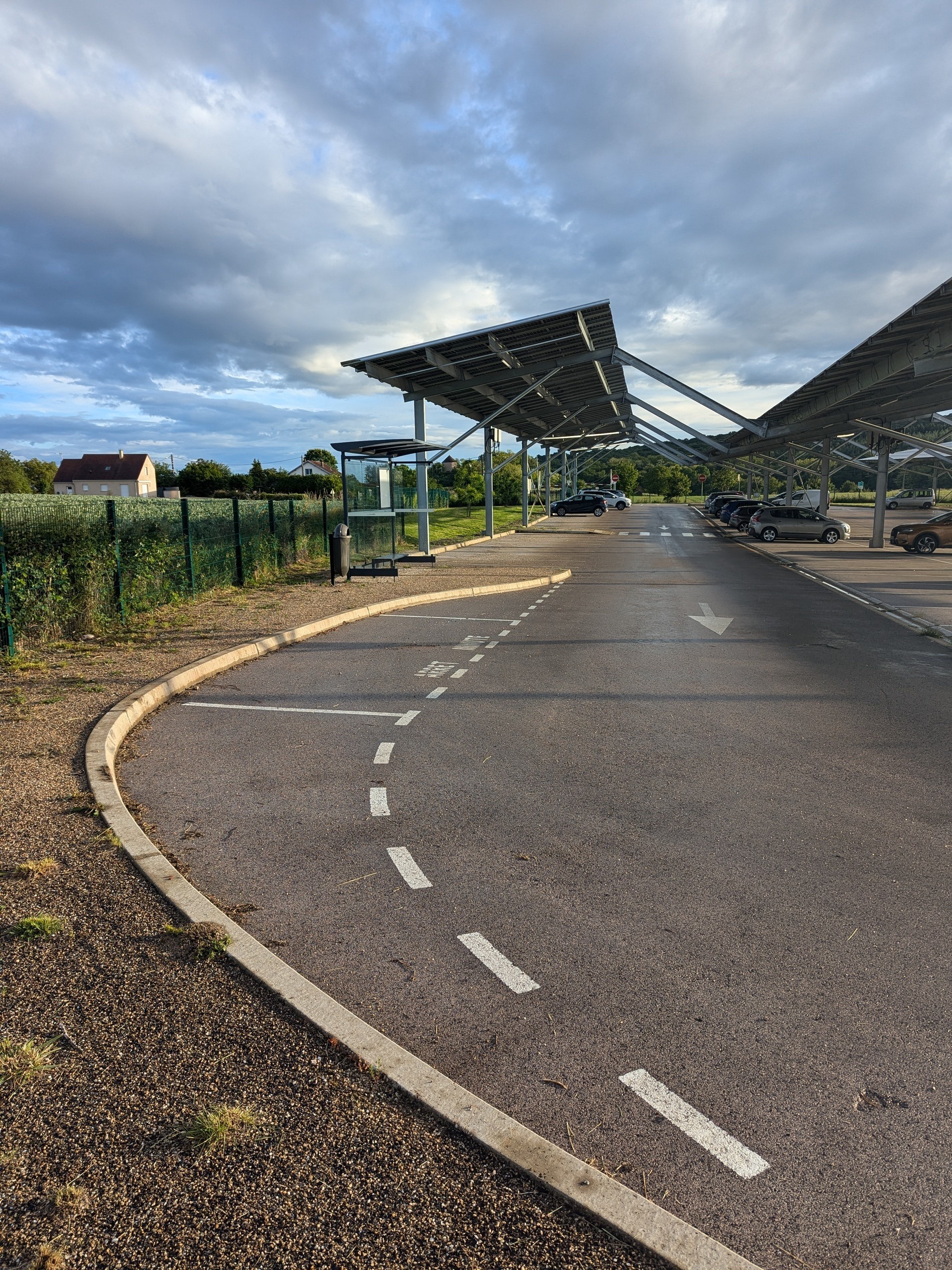Vue latérale d’un parking de covoiturage avec panneaux solaires.